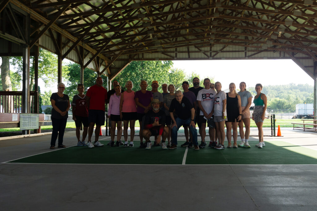 Group photo of participants at the Ellettsville pickleball event, standing together on the new courts.